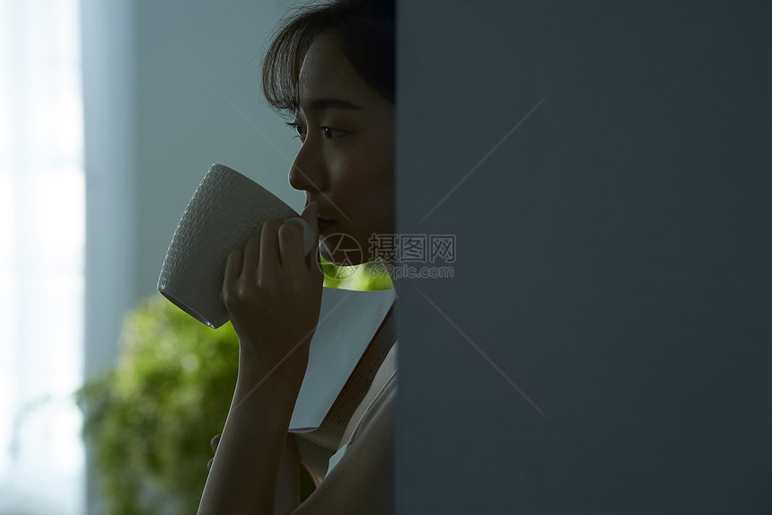 窗户旁边喝茶的女人图片