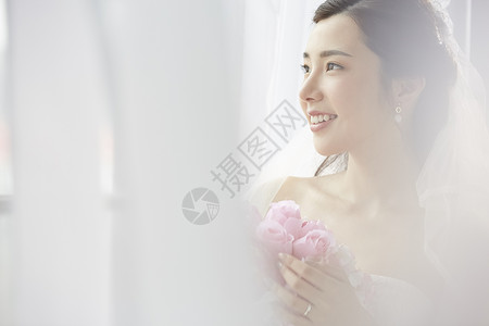 披着婚纱的新娘抱着手捧花花卉高清图片素材