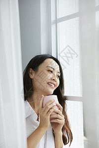 窗边喝茶的女人图片