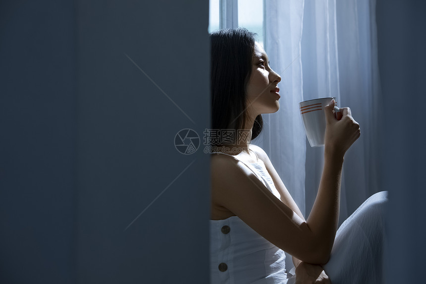 孤独美女窗边喝水图片