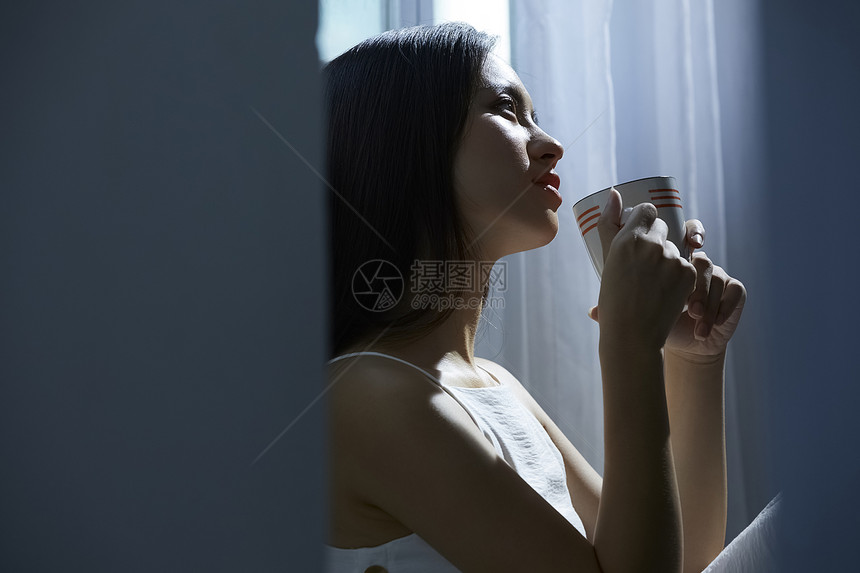 孤独美女窗边喝水图片