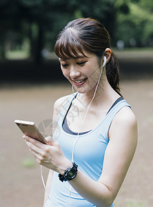 看着手机微笑的运动女性图片