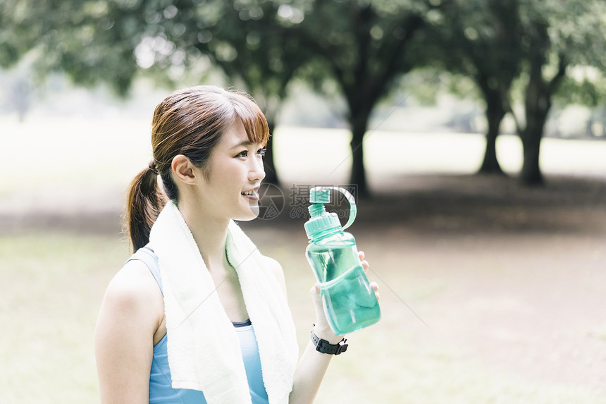 公园拿着水瓶的运动女青年