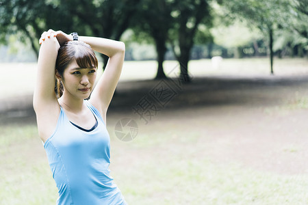 公园里舒展身体拉伸的年轻女子图片