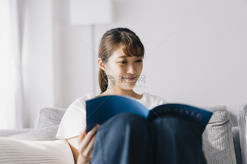 居家阅读看杂志放松的年轻女子图片