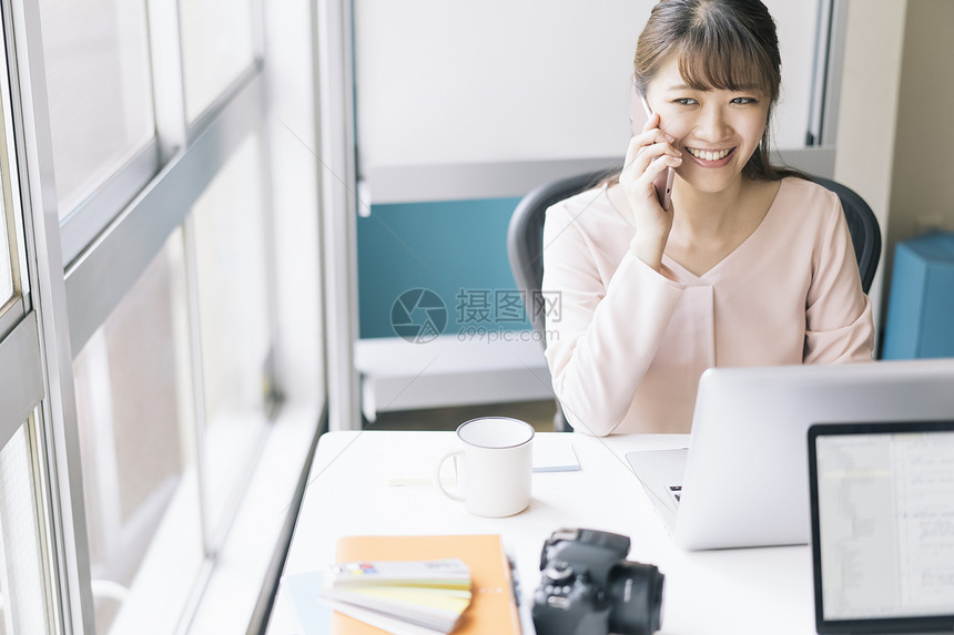 办公室接听电话微笑的女青年图片