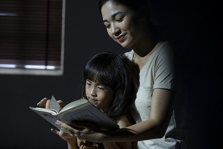 晚上妈妈给女儿阅读书籍好朋友高清图片素材