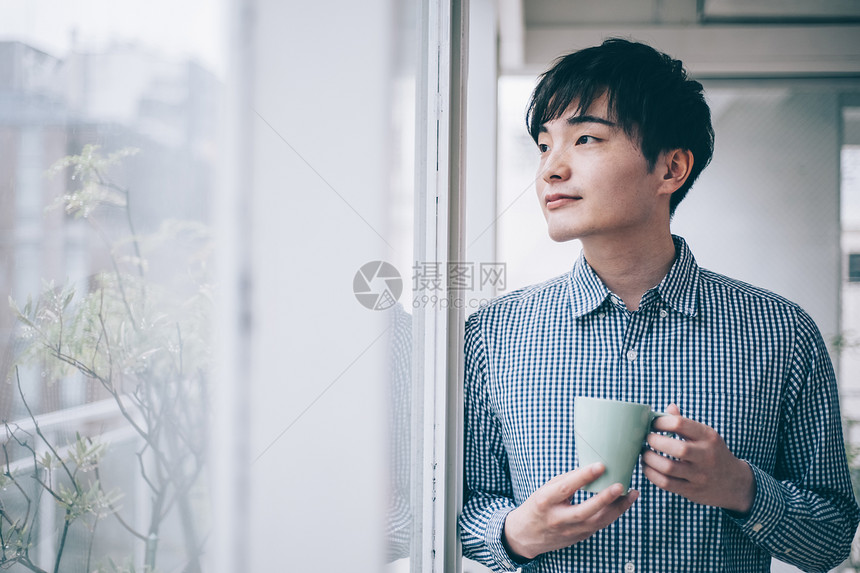 窗边喝茶的男士图片