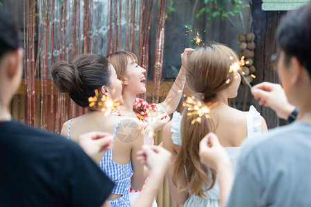 派对上放烟花的年轻女子庆祝高清图片素材