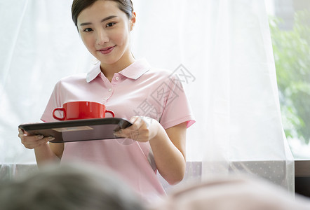 年轻女性端着餐盘图片