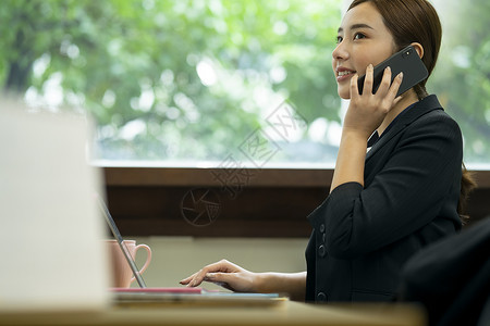 接听电话商谈工作的商务女性微笑高清图片素材
