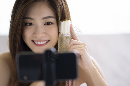 年轻女人手机视频直播分享美妆产品货品高清图片素材