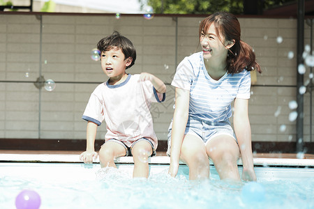 微笑30多岁少女家庭父母和孩子在游泳池玩耍图片