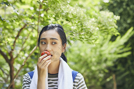 户外吃西红柿的女人青春高清图片素材