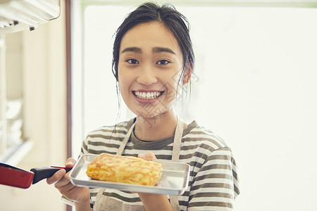 端着鸡蛋卷开心的年轻女子图片