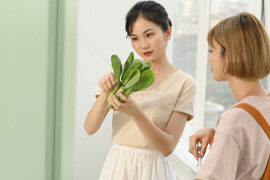 拿着青菜的年轻女子图片