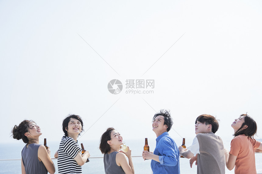 海边聚会喝酒的青年伙伴图片