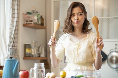 手拿厨具的青年女子图片