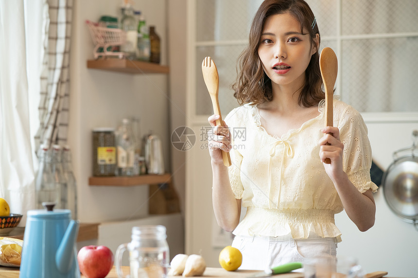 手拿厨具的青年女子图片