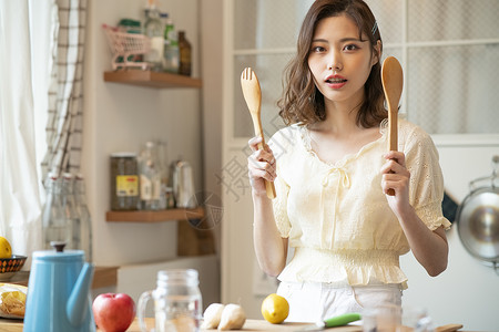 手拿厨具的青年女子图片