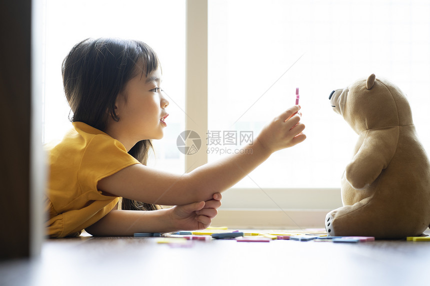 小女孩和玩具熊一起学习认识字母图片