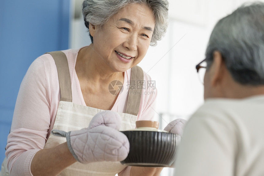 端着饭菜微笑的老年女性图片