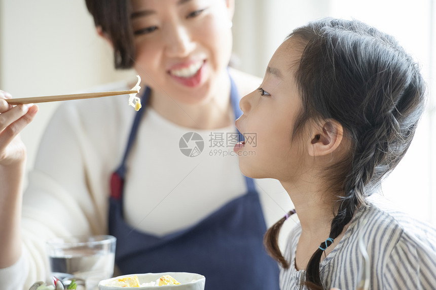 母亲照顾女儿吃饭喂饭图片