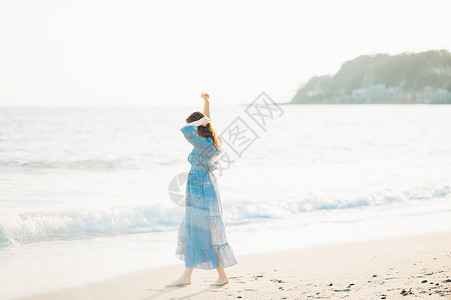 海边漫步的青年女子背影图片