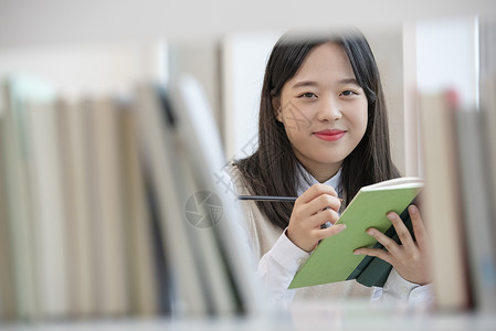 高中女学生在书架上查找书本高清图片