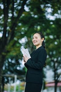 拿着书微笑的商务女性图片