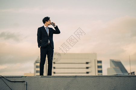 户外天台喝咖啡的商务男士图片