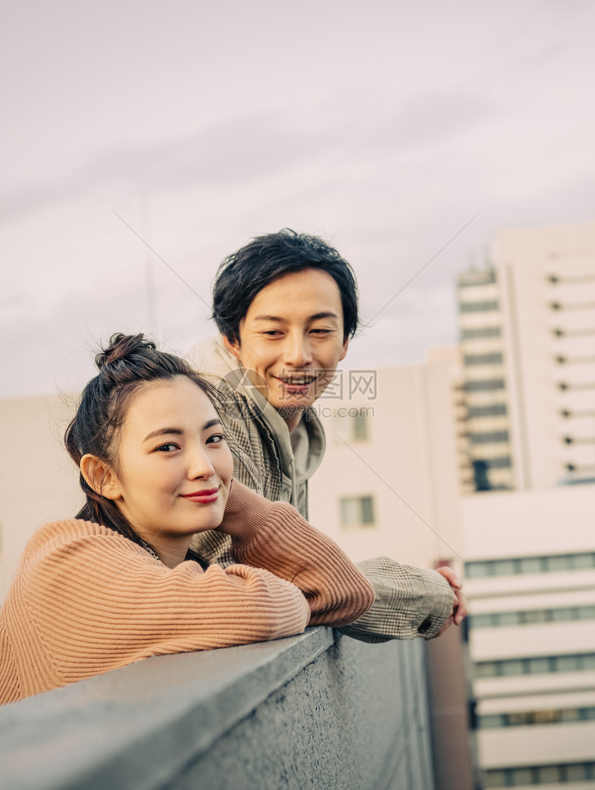 天台上眺望风景的年轻情侣图片