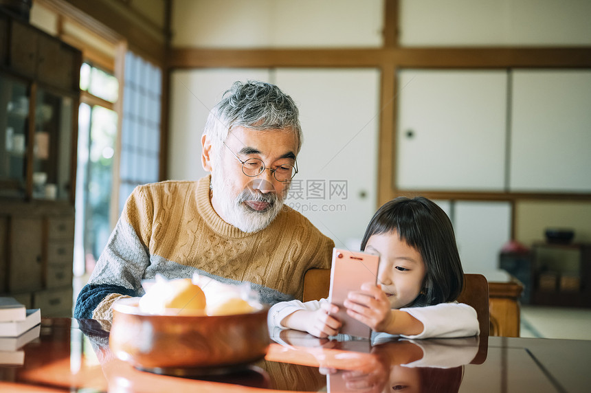 使用智能手机的祖孙图片