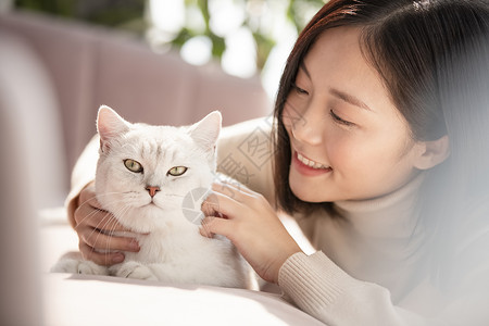 年轻女子与猫咪亲昵互动图片