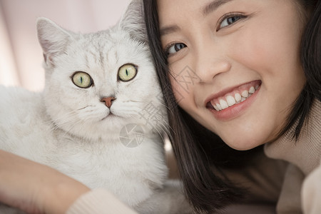 抱着宠物猫咪开心的年轻女子图片