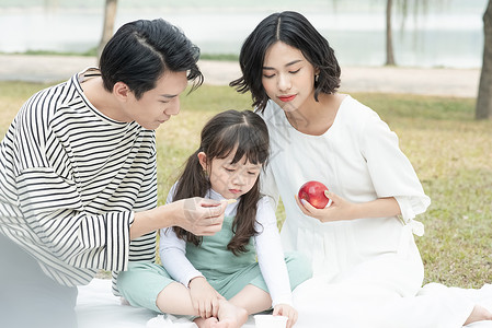 水果玩亚洲人父母和孩子在公园里野餐图片