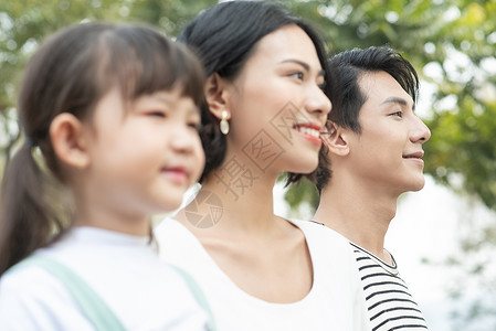 开心笑脸女生父母和孩子在户外玩的肖像图片