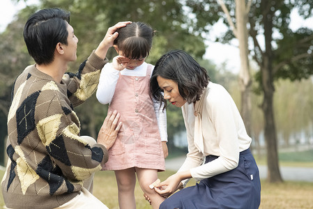 父母担心安慰受伤的小女孩小学生高清图片素材