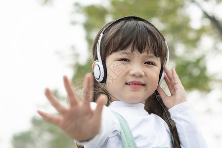 户外戴着耳机听音乐的小女孩图片