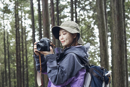 假日徒步旅行在山上拍照的女人图片