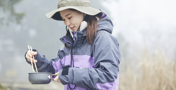 年轻女人徒步登山探险吃东西图片