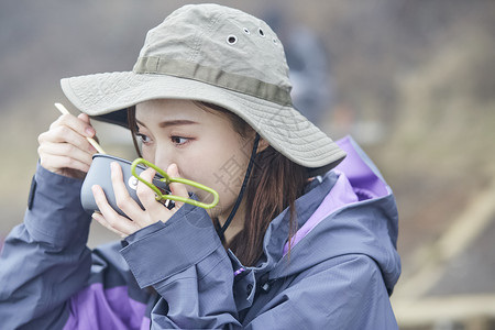 年轻女人徒步登山休息吃面图片