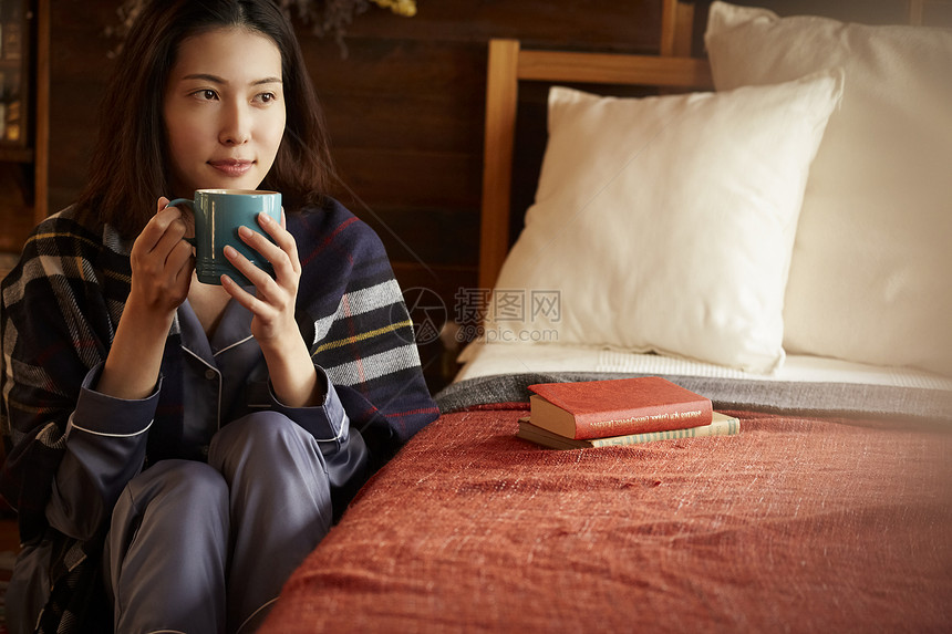 居家卧室捧着咖啡的青年女子图片