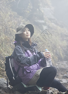 年轻女人徒步登山探险休息喝水图片