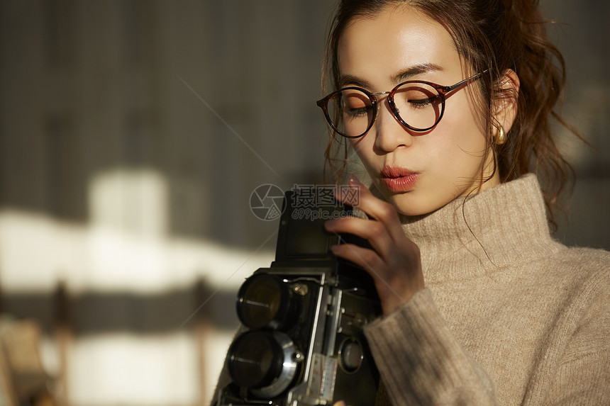 拿着相机的年轻女子图片