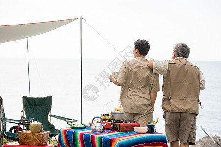 享受户外活动露营野餐的父子俩背影图片