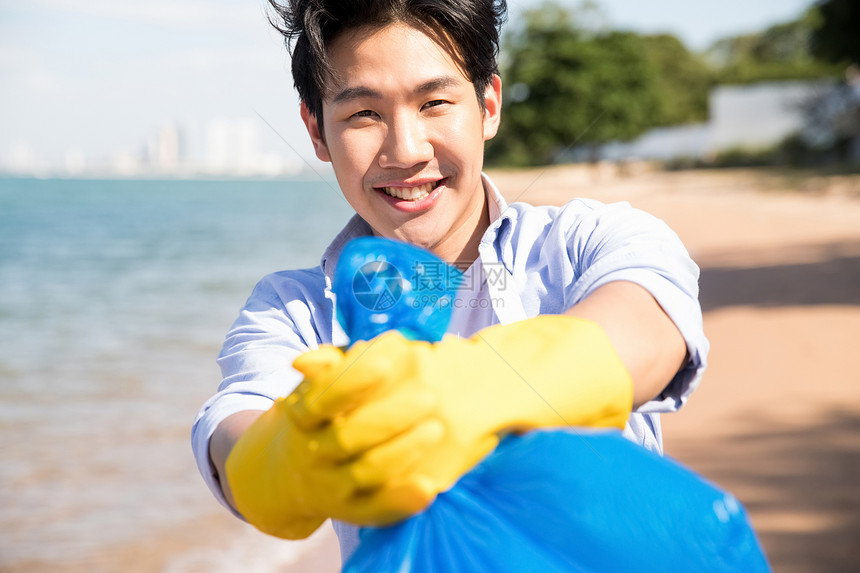 国外旅游蓝色的水步行男子打扫海滩图片