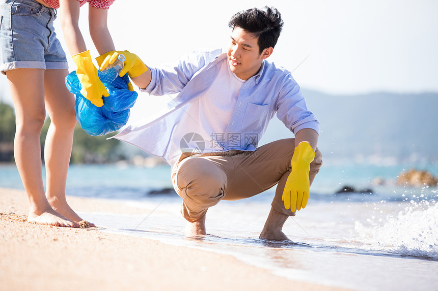 女干净国外旅游男人和女人做海滩清洁图片