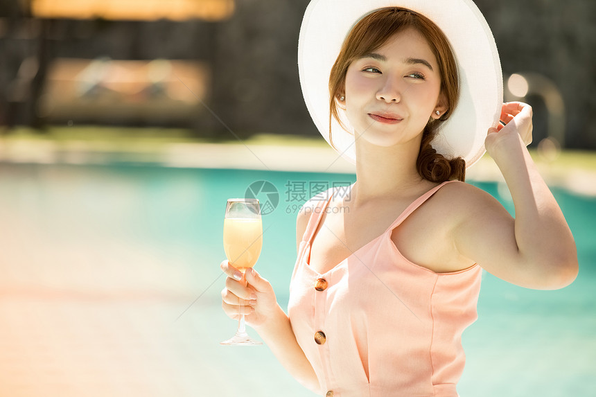 南国鸡尾酒幸福年轻女子在游泳池旁享受度假之旅图片