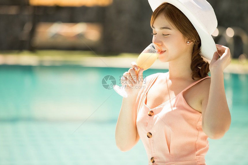 旅游业美丽池畔年轻女子在游泳池旁享受度假之旅图片
